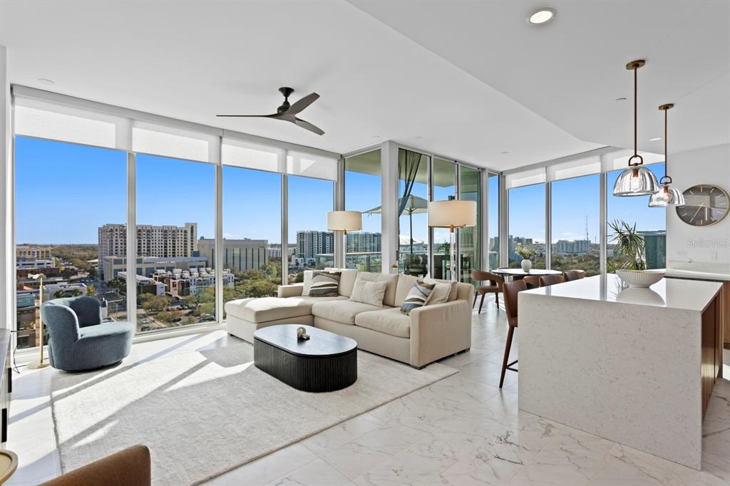 A modern living room and kitchen area with floor-to-ceiling windows and marble flooring — 777 3RD AVENUE N UNIT 1208, ST PETERSBURG, FL