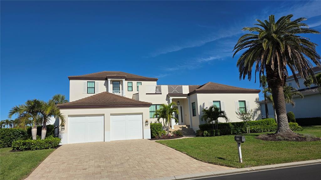 A two-story stucco house with a two-car garage, palm trees, and a paved driveway — 531 BIRDIE LANE, LONGBOAT KEY, FL