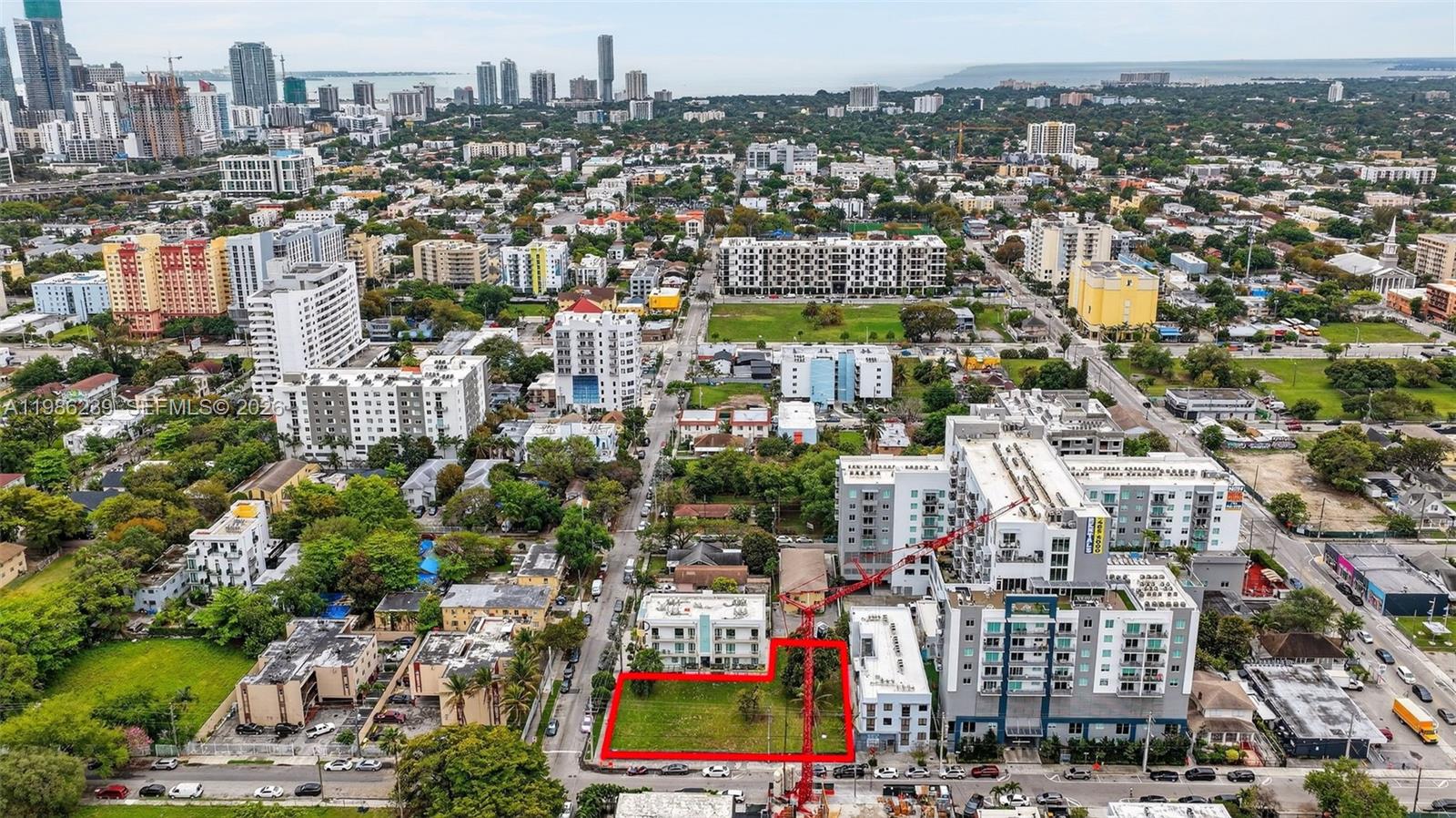 An aerial view shows a vacant rectangular lot outlined in red next to apartment buildings — 244 NW 7th Ave, Miami FL 33128, MIAMI, FL