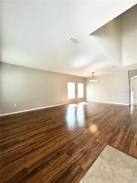 A spacious living area features wood-look flooring, light gray walls, and a high ceiling — 4612 CABALERRO TRAIL, KISSIMMEE, FL