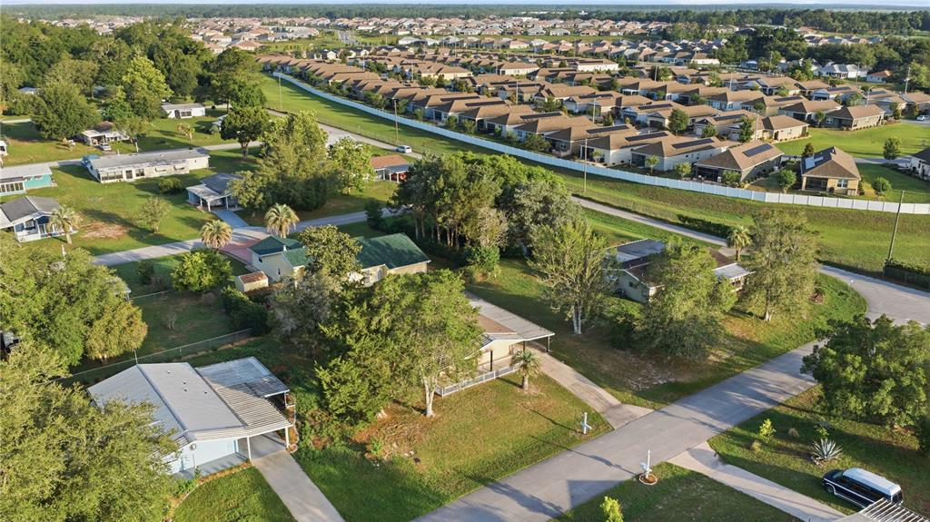 An aerial view shows several single-story houses with driveways surrounded by trees and grassy lawns — 10040 SW 98TH AVENUE, OCALA, FL