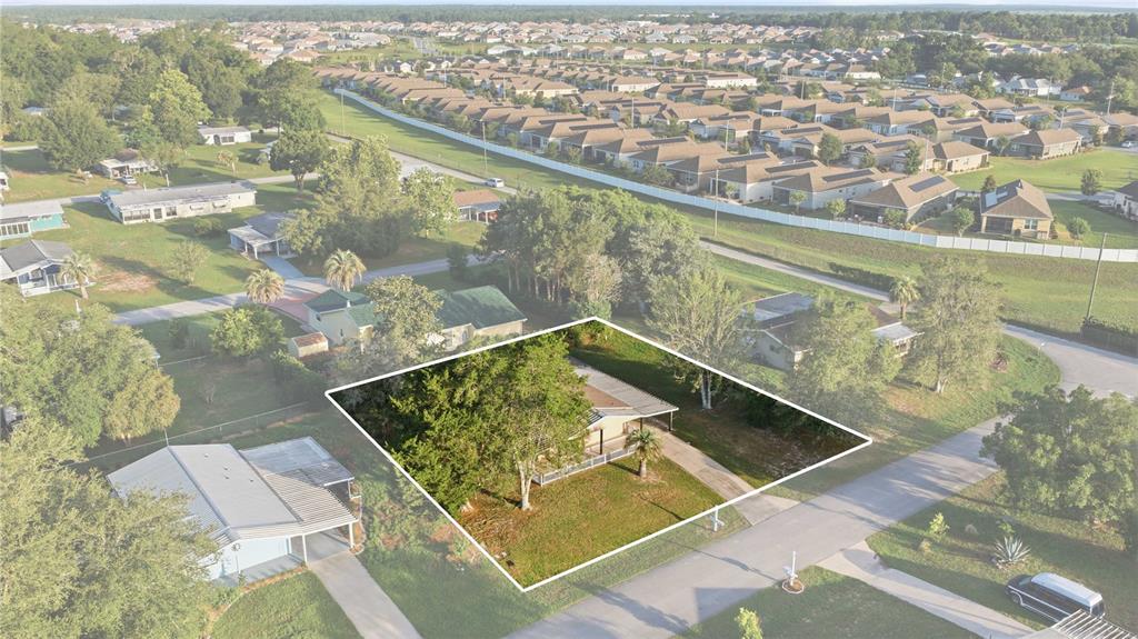 An aerial view shows a single-story house with a driveway and trees on a lot — 10040 SW 98TH AVENUE, OCALA, FL