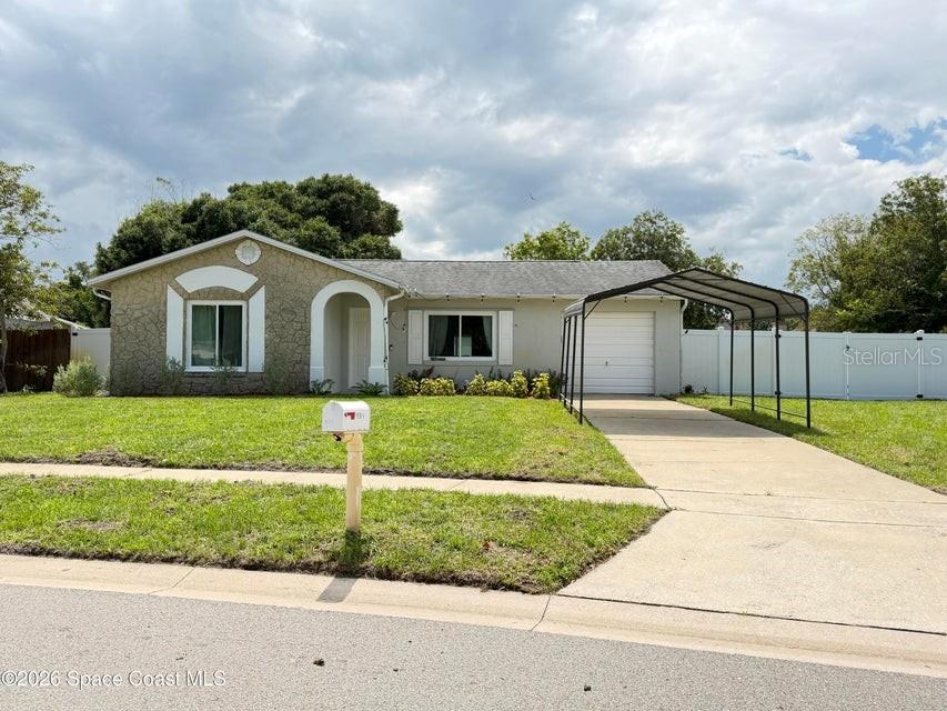 A single-story house with a stone facade, a carport, and a white vinyl fence — 1578 W POWDER HORN ROAD, TITUSVILLE, FL