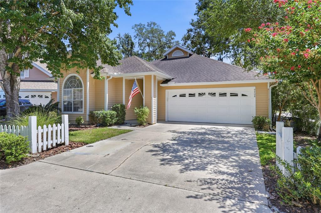 A yellow single-story house with a white garage door and a concrete driveway — 9408 SW 39TH AVENUE, GAINESVILLE, FL