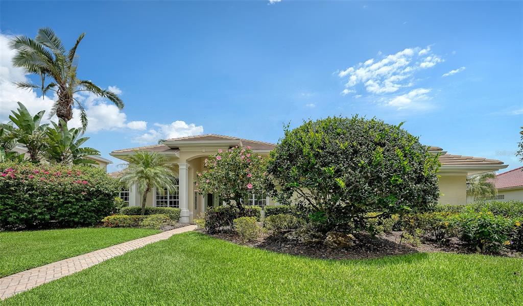 A single-story house with a tiled roof, landscaped front yard, and a paved walkway — 8923 BLOOMFIELD BOULEVARD, SARASOTA, FL