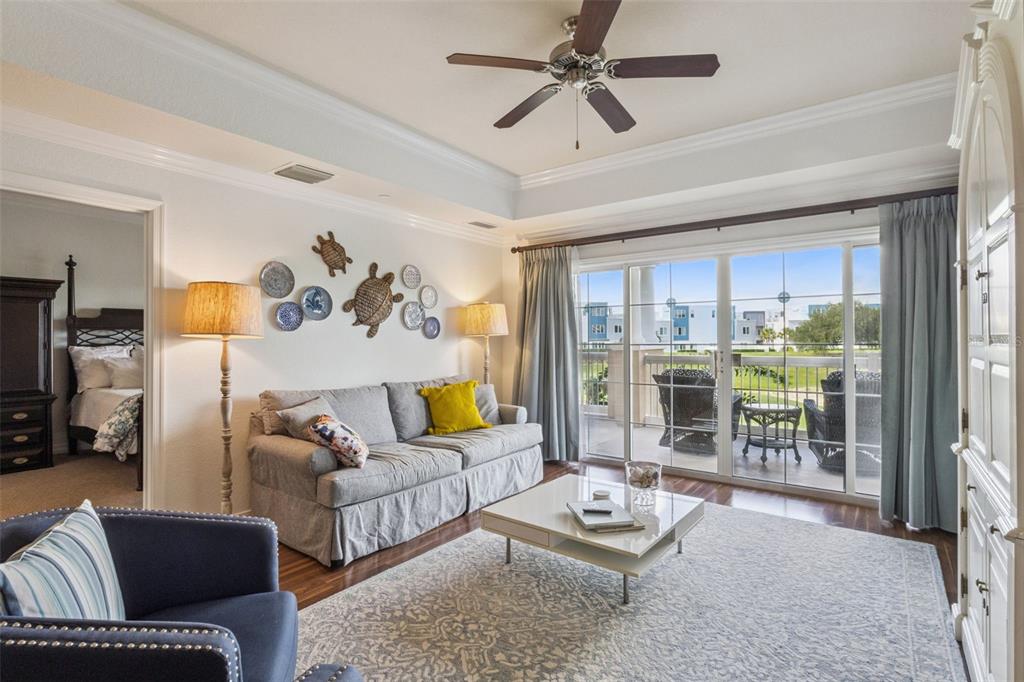 A living room features a grey sofa, a coffee table, and sliding doors to a balcony — 1112 SUNSET VIEW CIRCLE UNIT 203, KISSIMMEE, FL