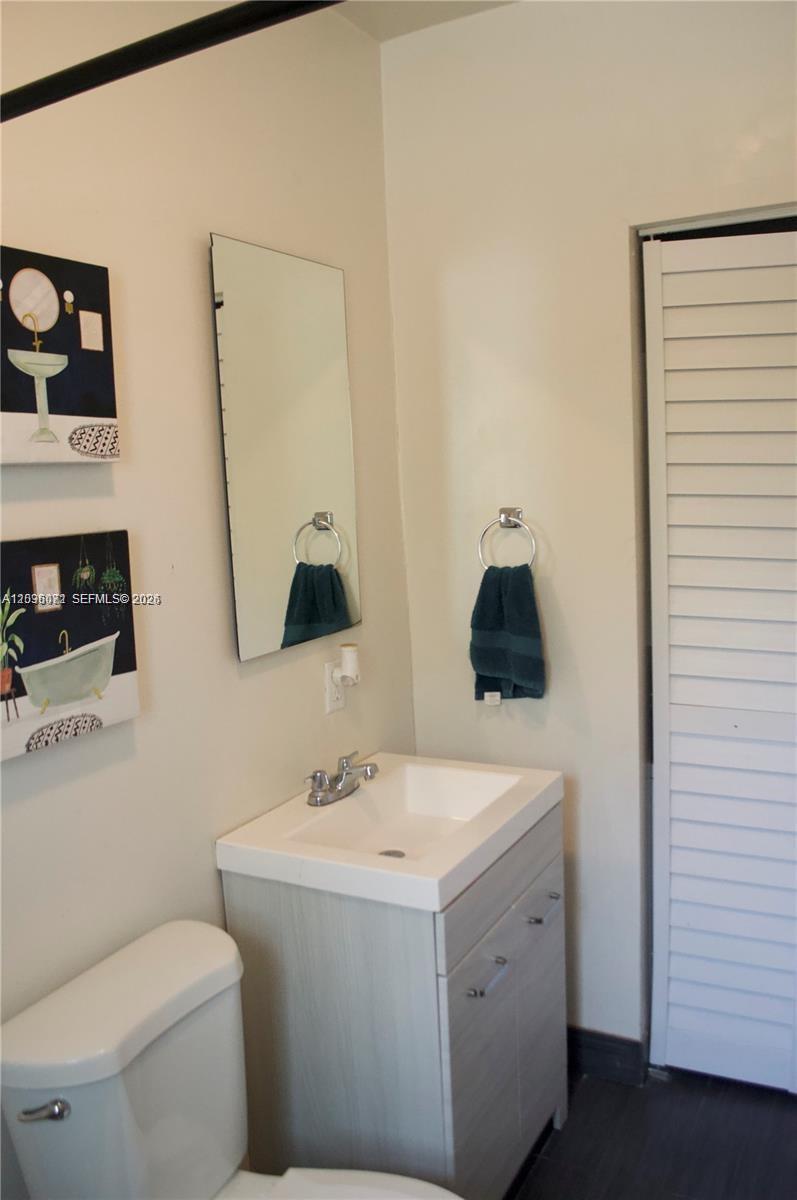A bathroom features a vanity with a white sink, a mirror, and wall art — 5530 N Miami Ave # 2, Miami FL 33127, MIAMI, FL