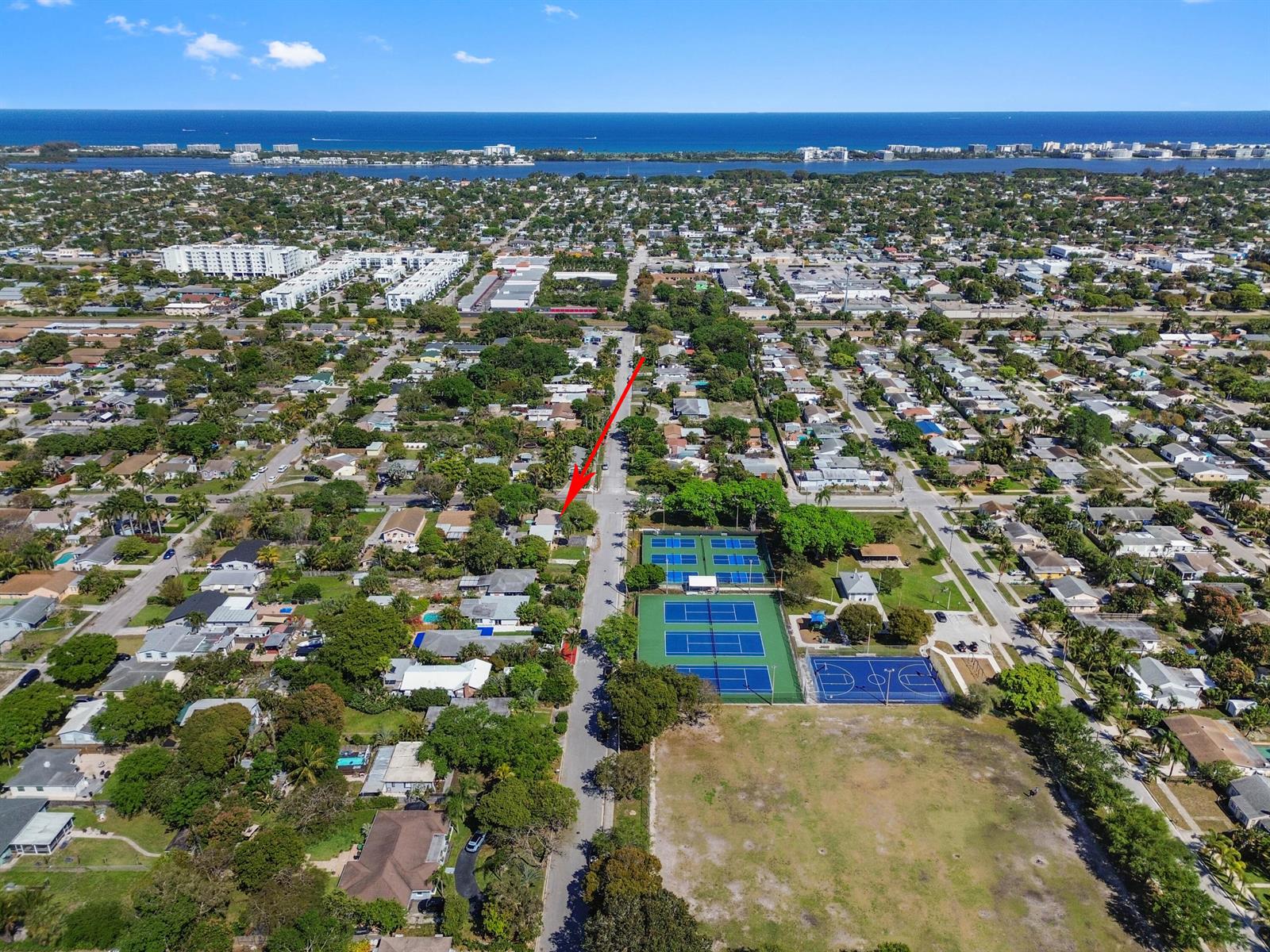 An aerial view shows a residential neighborhood with a park featuring tennis and basketball courts — 1501 N D Street, FL 33460, FL