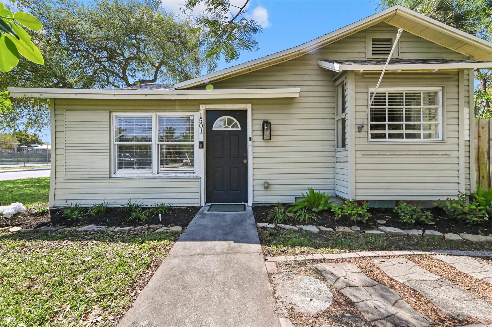 A light green, single-story house with a black front door and a concrete walkway — 1501 N D Street, FL 33460, FL