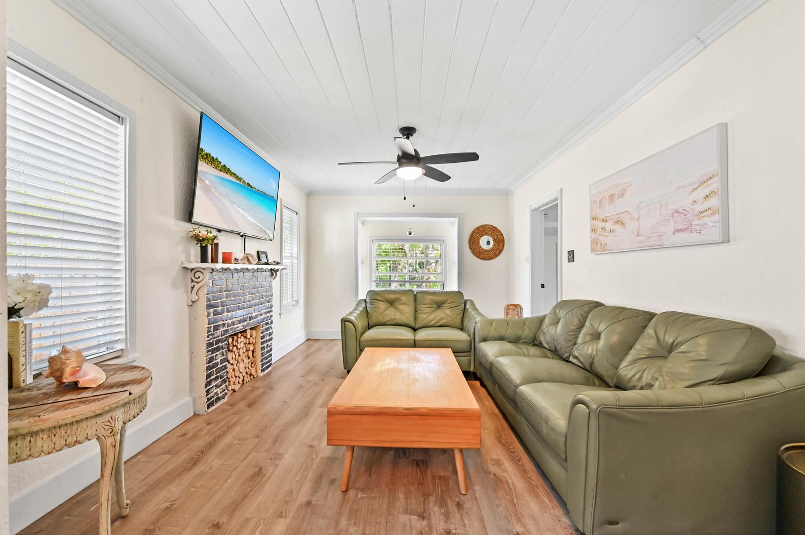 A living room features a brick fireplace, green leather sofas, and a wood coffee table — 1501 N D Street, FL 33460, FL