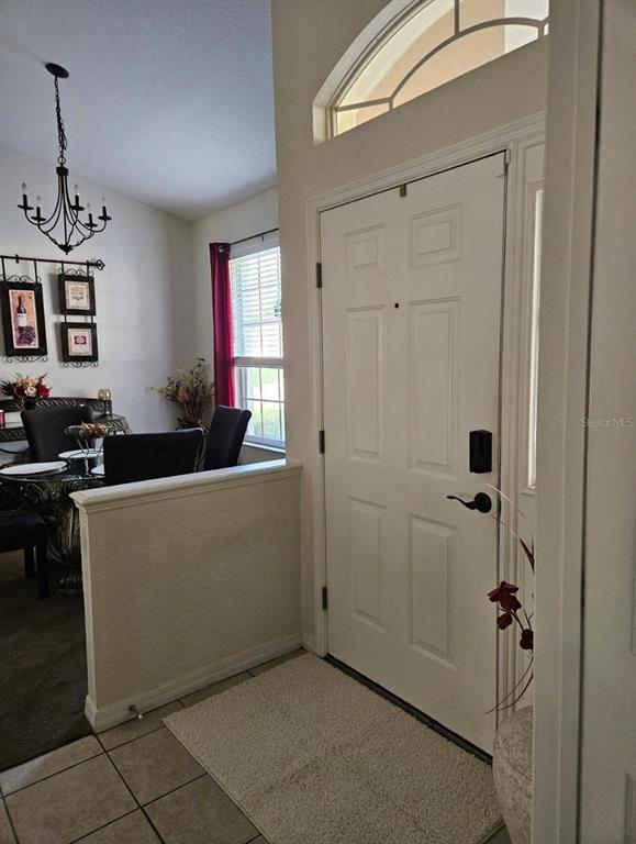 An entryway features a white front door, a half wall, and a dining area — 5419 OXFORD MANOR CIRCLE, LAKELAND, FL