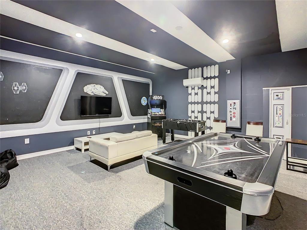 A Star Wars-themed game room features an air hockey table, foosball table, and wall-mounted television — 1305 DIVOT WAY, DAVENPORT, FL