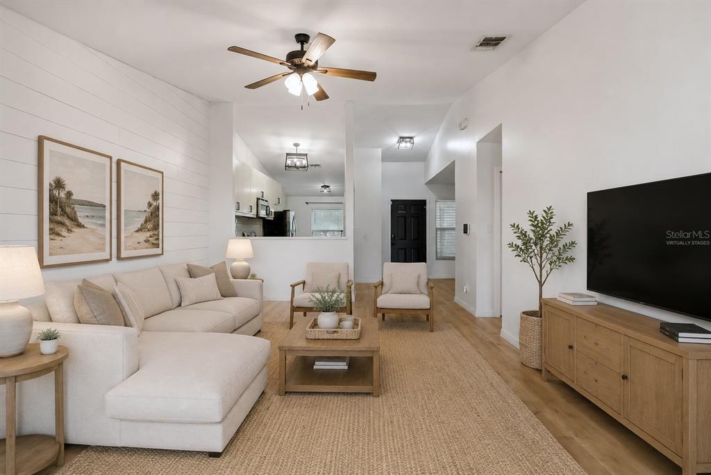 A living room features a sectional sofa, two armchairs, a coffee table, and a television — 1107 COVINGTON STREET, OVIEDO, FL