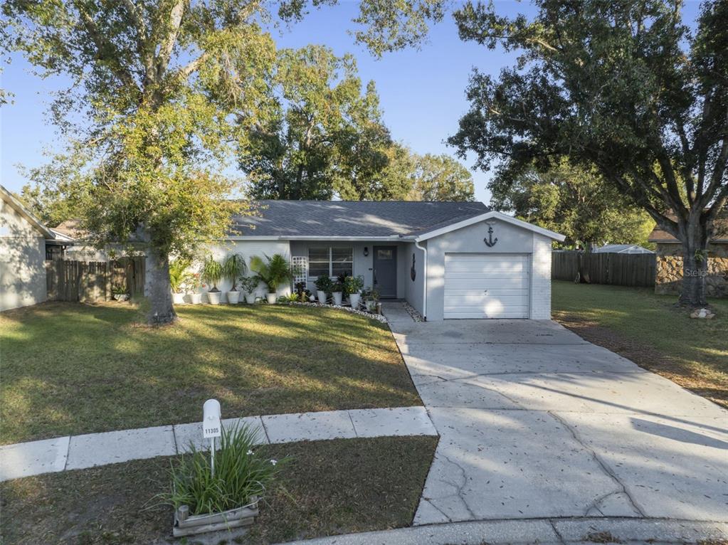 A single-story house with a gray exterior, a one-car garage, and a landscaped front yard — 11305 SILVERLEAF COURT, RIVERVIEW, FL