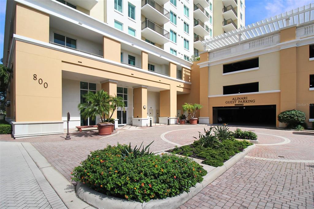 The exterior of a multi-story building features a guest parking entrance and landscaped circular driveway — 800 N TAMIAMI TRAIL UNIT 806, SARASOTA, FL
