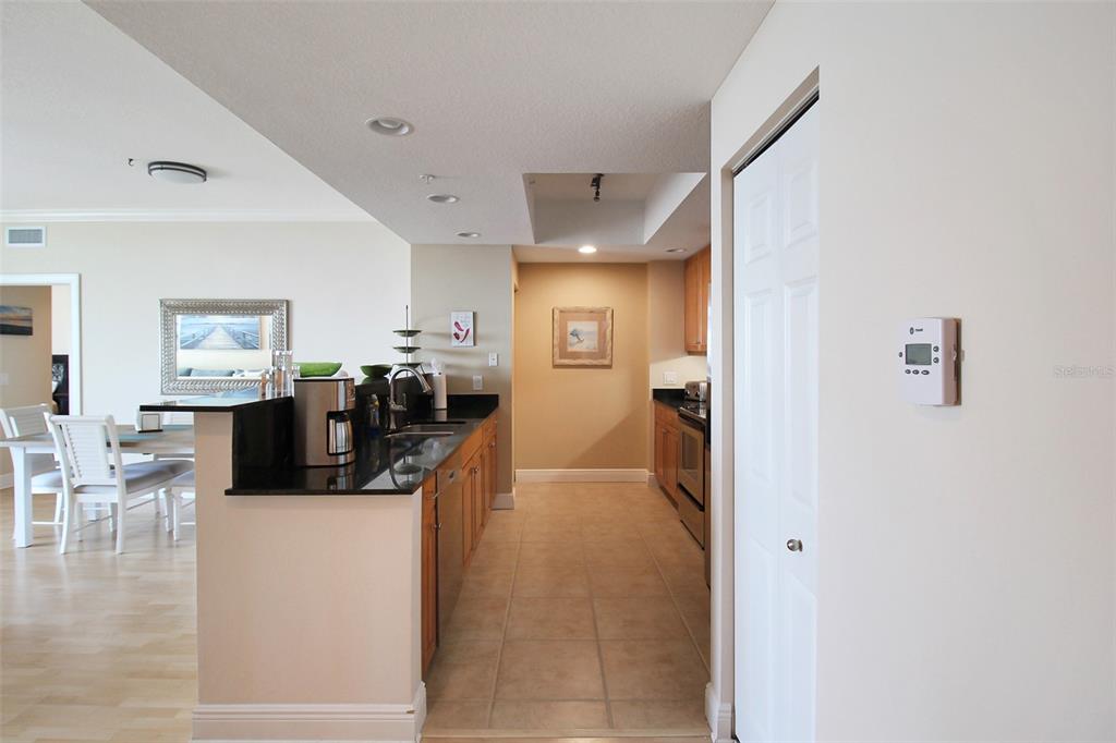 A kitchen with dark countertops and wood cabinets opens to a dining area — 800 N TAMIAMI TRAIL UNIT 806, SARASOTA, FL