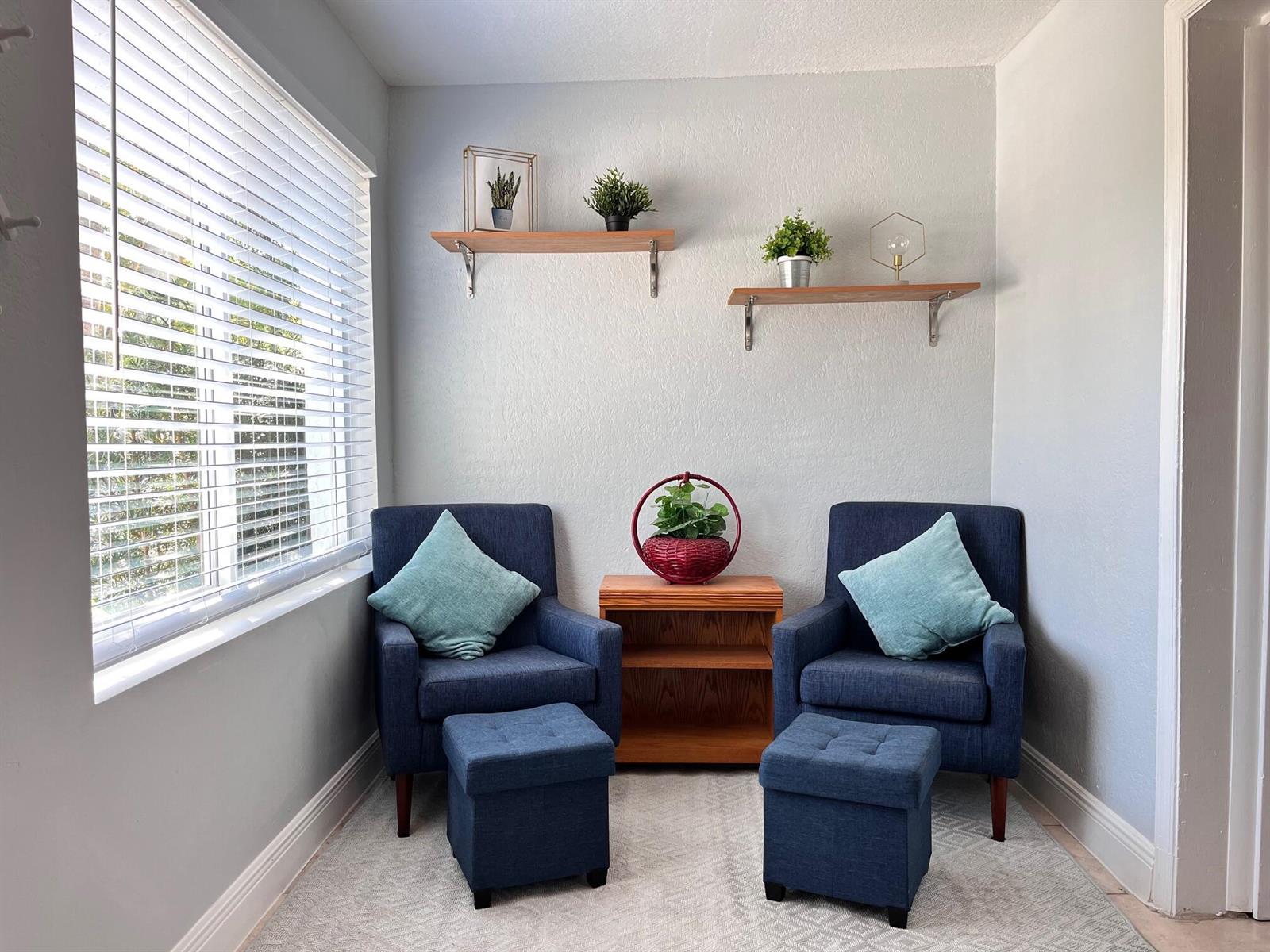 A small sitting area features two blue armchairs with matching ottomans and two wall shelves — 118 SW 12th Avenue, Delray Beach FL 33444, DELRAY BEACH, FL