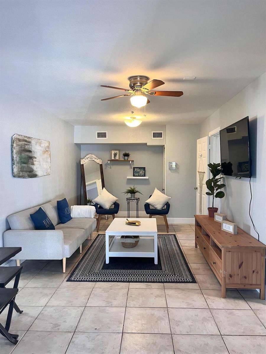 A living room features a grey sofa, a white coffee table, and a wooden media console — 118 SW 12th Avenue, Delray Beach FL 33444, DELRAY BEACH, FL