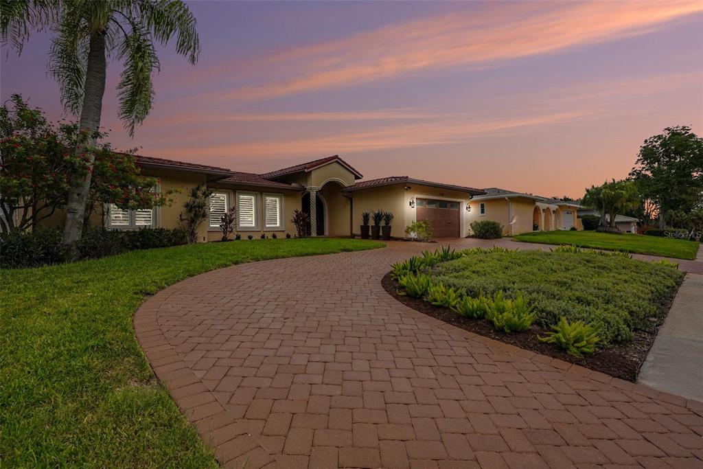A single-story house with a paved driveway and palm tree at sunset — 3316 SAN JOSE STREET, CLEARWATER, FL