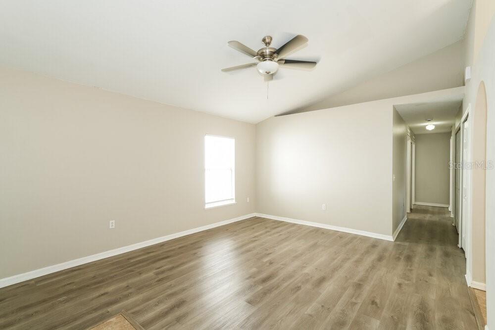 An empty room with light-colored walls, wood-look flooring, and a ceiling fan — 17031 ONGAR COURT, LAND O LAKES, FL
