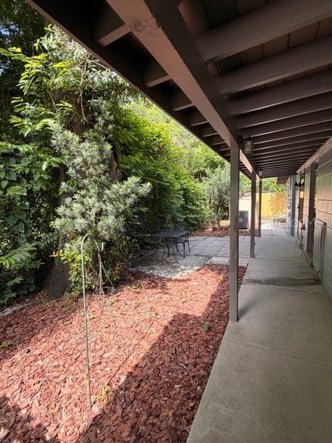 A covered concrete walkway leads to a small patio area with a table and chairs — 250 CEDARWOOD DRIVE, MAITLAND, FL