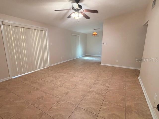 A concrete patio with a small table and chairs sits beneath a covered wooden porch — 250 CEDARWOOD DRIVE, MAITLAND, FL