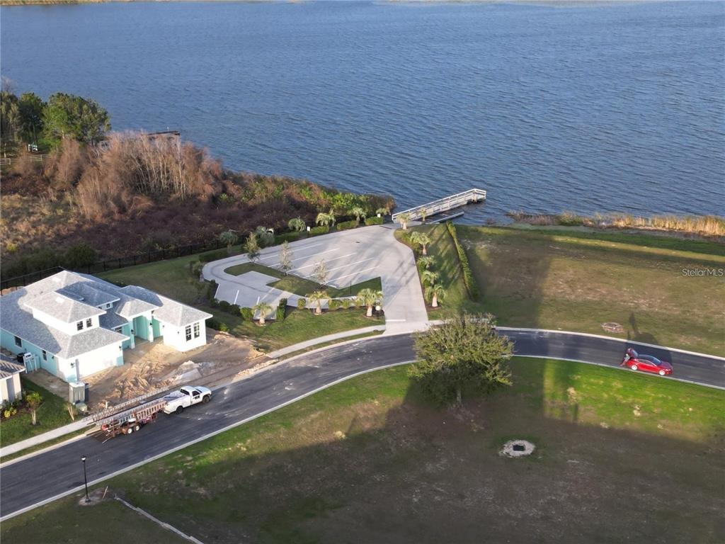 An aerial view shows a house, a parking lot, a boat dock, and a lake — 402 WATERFERN TRAIL DRIVE, AUBURNDALE, FL