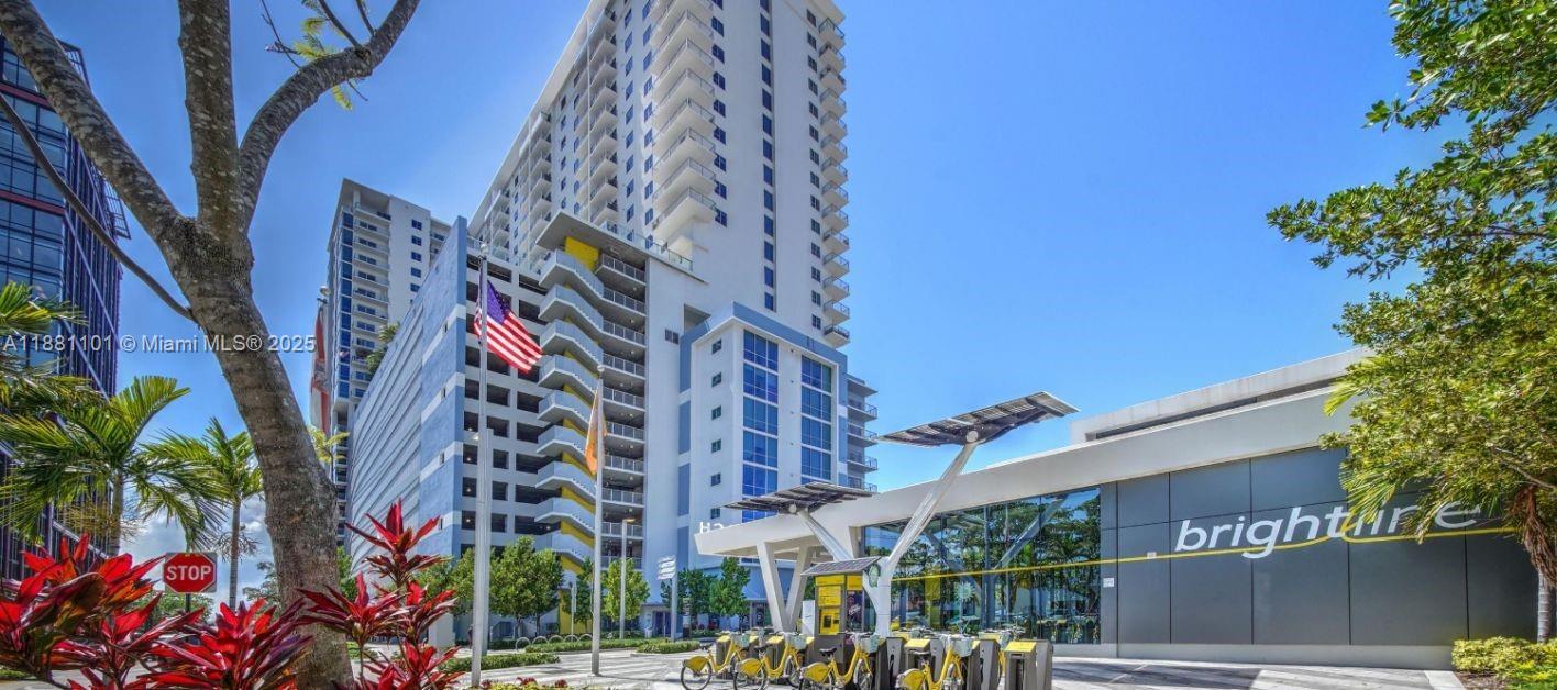 An exterior view of a modern high-rise building next to a Brightline station entrance — 591 Evernia  Sreet # B1, West Palm Beach FL 33401, WEST PALM BEACH, FL