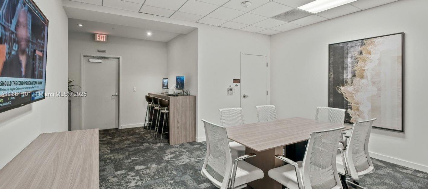 A modern office conference room features a central table, chairs, and a wall-mounted television — 591 Evernia  Sreet # B1, West Palm Beach FL 33401, WEST PALM BEACH, FL