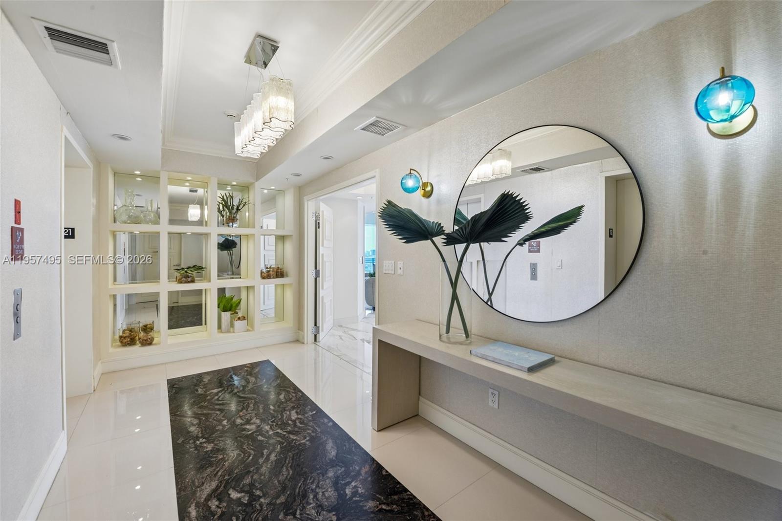 A modern entryway features a marble floor inlay, a console table, and a circular mirror — 3535 S Ocean Dr # 2106, Hollywood FL 33019, HOLLYWOOD, FL