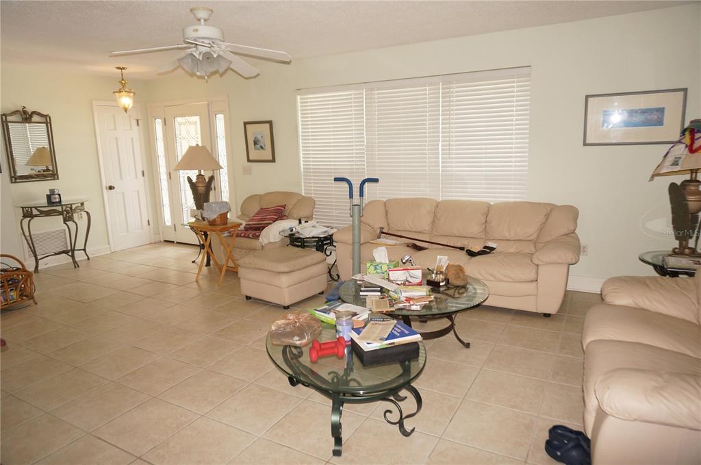 A living room features beige leather furniture, a glass coffee table, and light tile flooring — 821 VIA TUNIS, PUNTA GORDA, FL