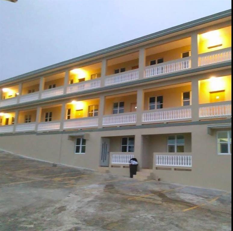 A three-story apartment building with exterior walkways, white railings, and a paved parking lot — Km 5.8 CARR 311, CABO ROJO, PR