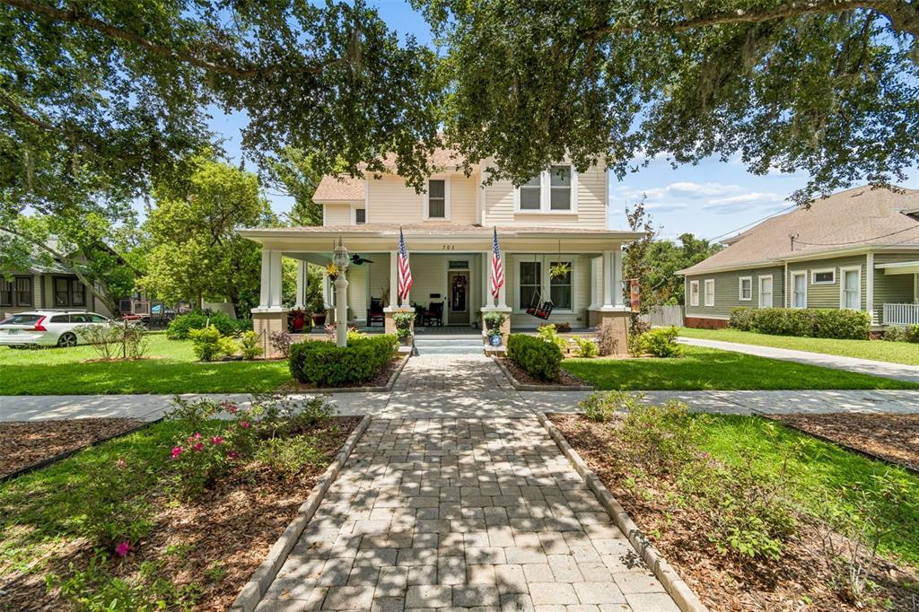 A two-story house with a front porch, American flags, and a stone walkway — 703 N EVERS STREET, PLANT CITY, FL
