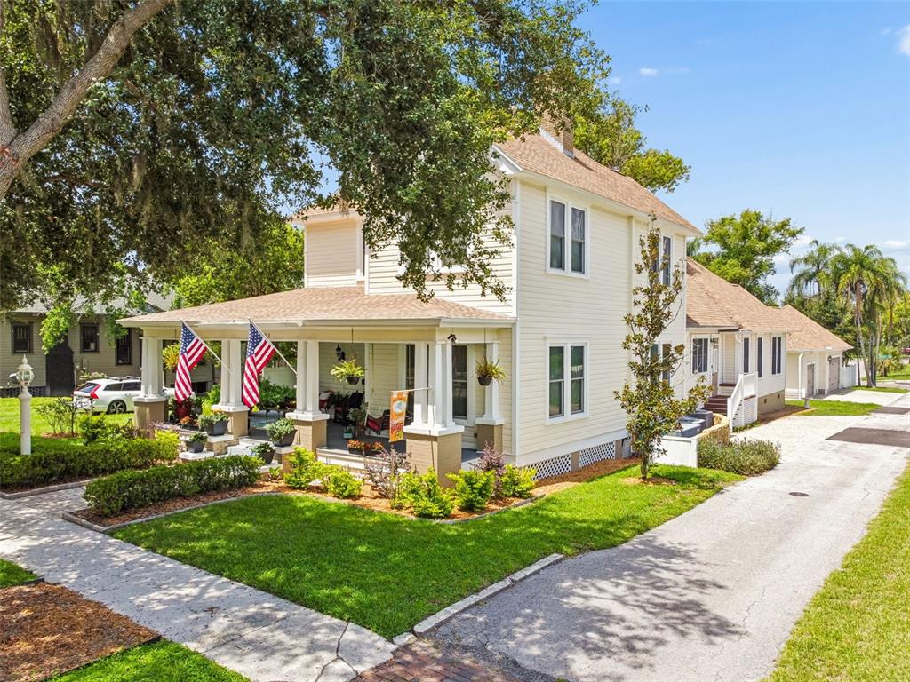 A two-story yellow house with a wrap-around porch and a long paved driveway — 703 N EVERS STREET, PLANT CITY, FL