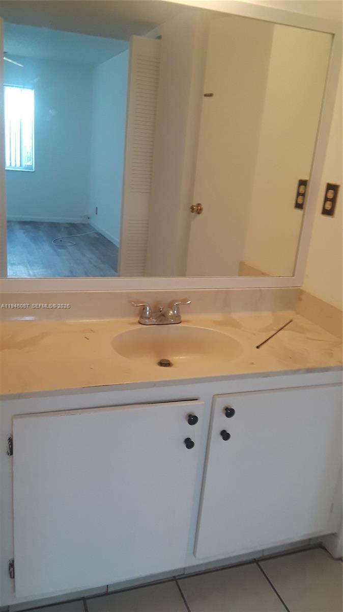 A bathroom vanity features a white cabinet, a beige countertop, and a large wall mirror — 4374 NW 9th Ave # 3G, Deerfield Beach FL 33064, DEERFIELD BEACH, FL