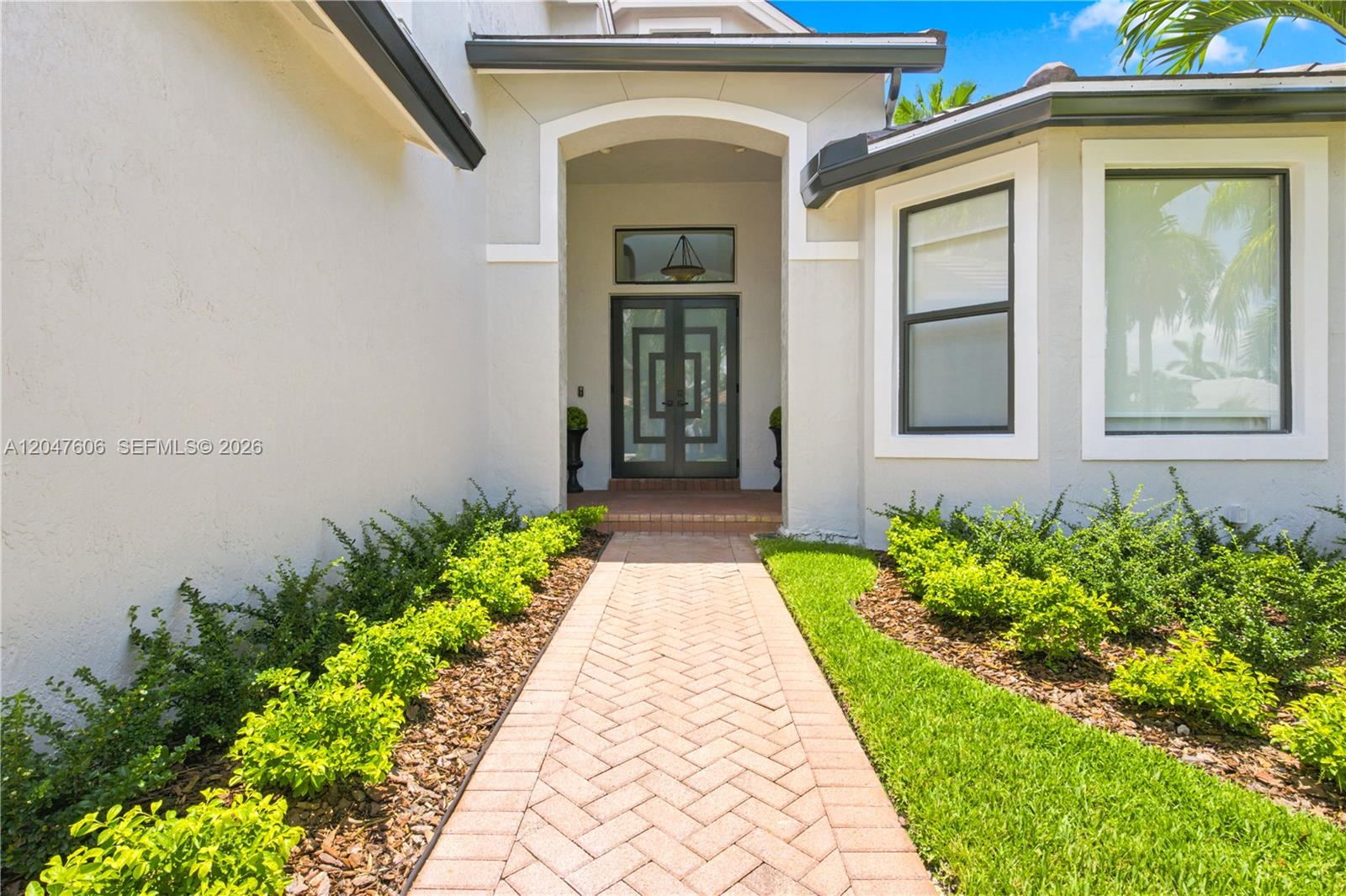 A paved walkway leads to the double front doors of a house with light-colored stucco — 3061 SW 189th Ter, Miramar FL 33029, MIRAMAR, FL