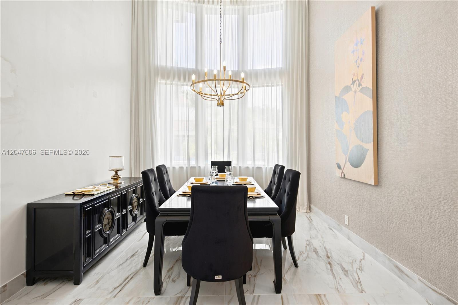 A formal dining room features a black table and chairs, chandelier, and marble flooring — 3061 SW 189th Ter, Miramar FL 33029, MIRAMAR, FL