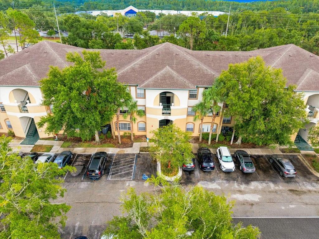 An aerial view shows a three-story apartment building with a parking lot in front — 17104 CARRINGTON PARK DRIVE UNIT 516, TAMPA, FL