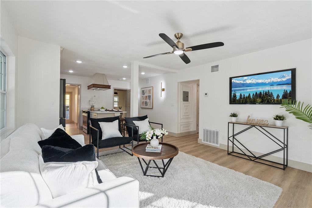 A living room with white walls, light wood floors, a ceiling fan, and black furniture — 1931 CLOVERLAWN AVENUE, ORLANDO, FL