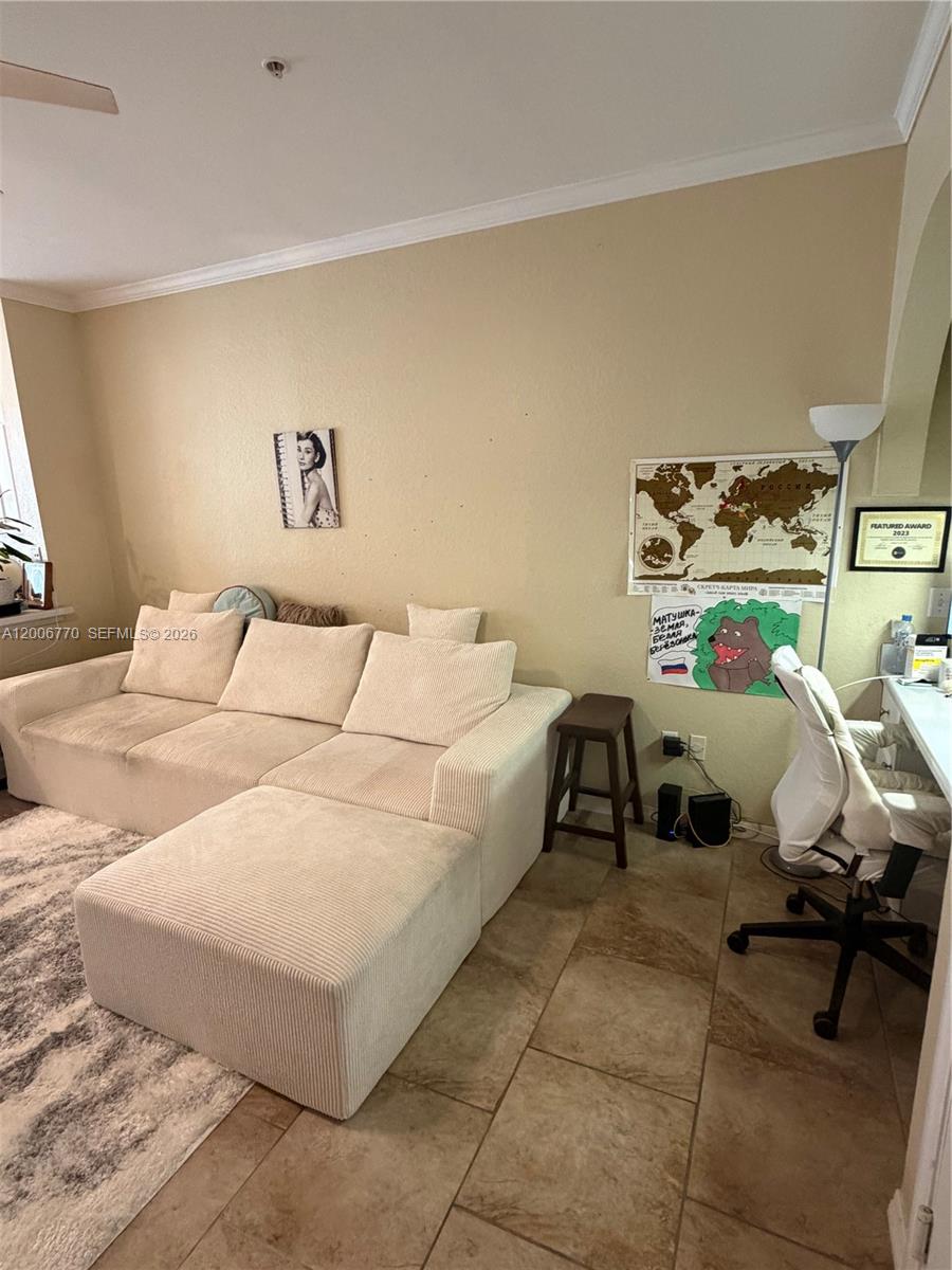 A living room features a beige sectional sofa, a small wooden stool, and a desk area — 860 N Orange Ave # 258, Orlando FL 33180, ORLANDO, FL