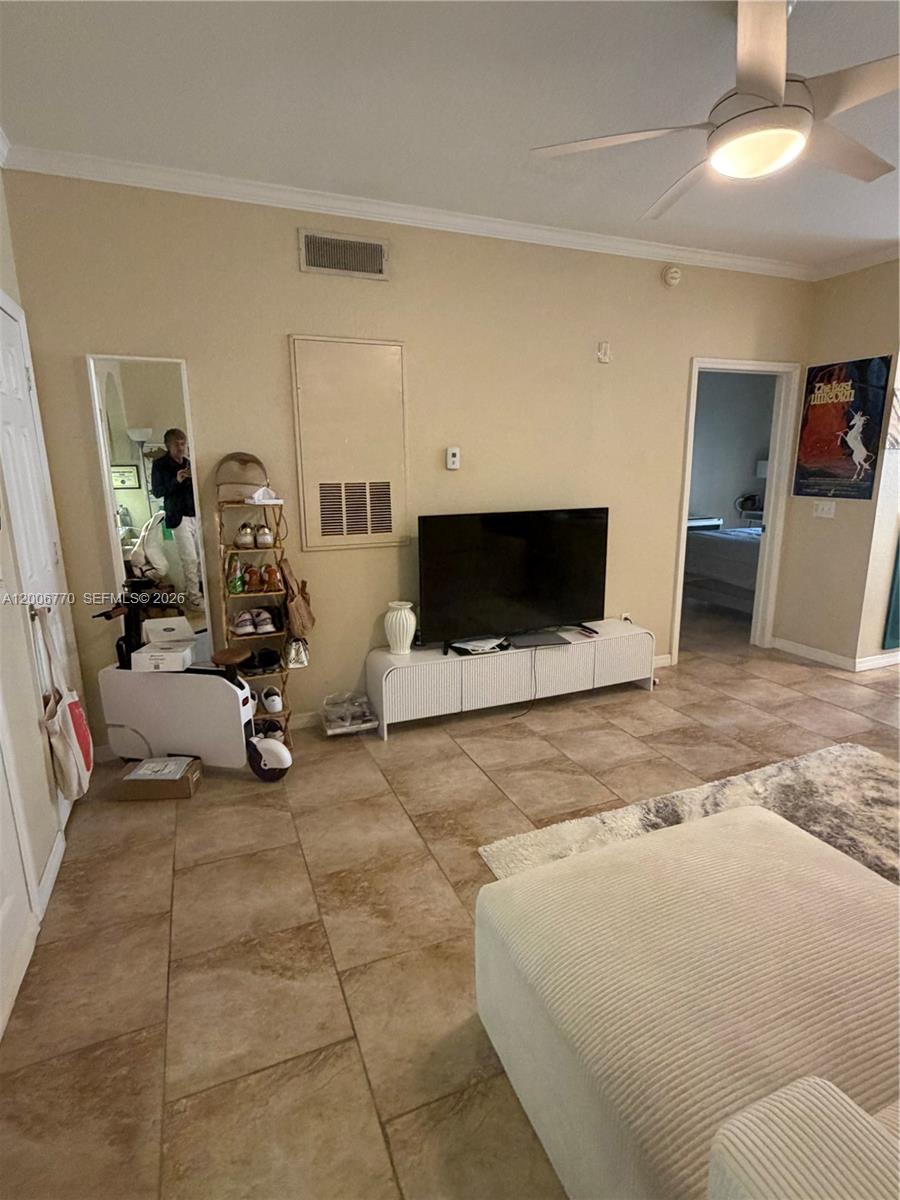 A living room features tile flooring, a television on a white console, and a ceiling fan — 860 N Orange Ave # 258, Orlando FL 33180, ORLANDO, FL