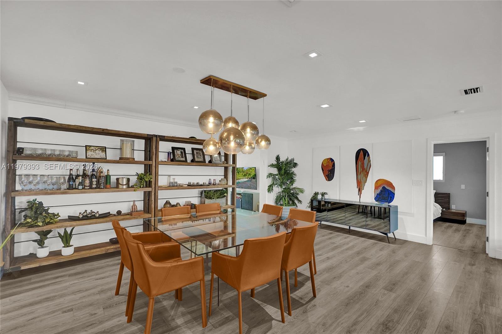 A dining room features a glass table, leather chairs, open shelving, and a modern light fixture — 2301 NE 196th St, Miami FL 33180, MIAMI, FL