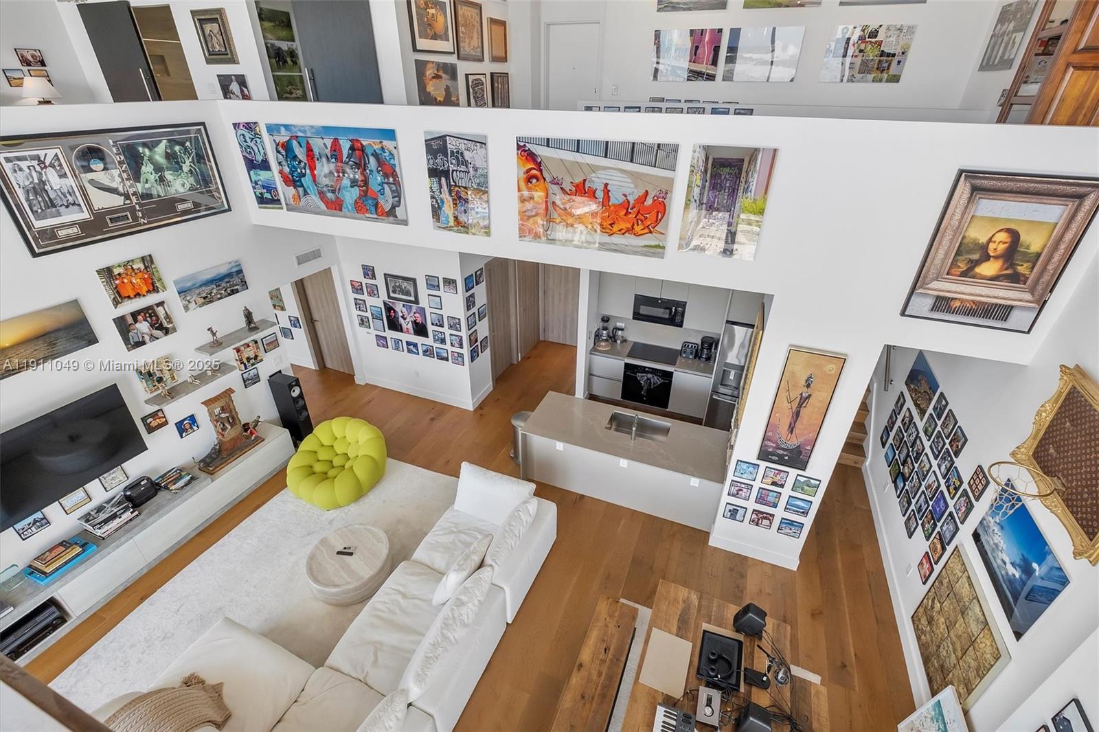 A high-angle view of a modern living room and kitchen featuring extensive wall art — 3470 E Coast Ave, Miami FL 33137, MIAMI, FL