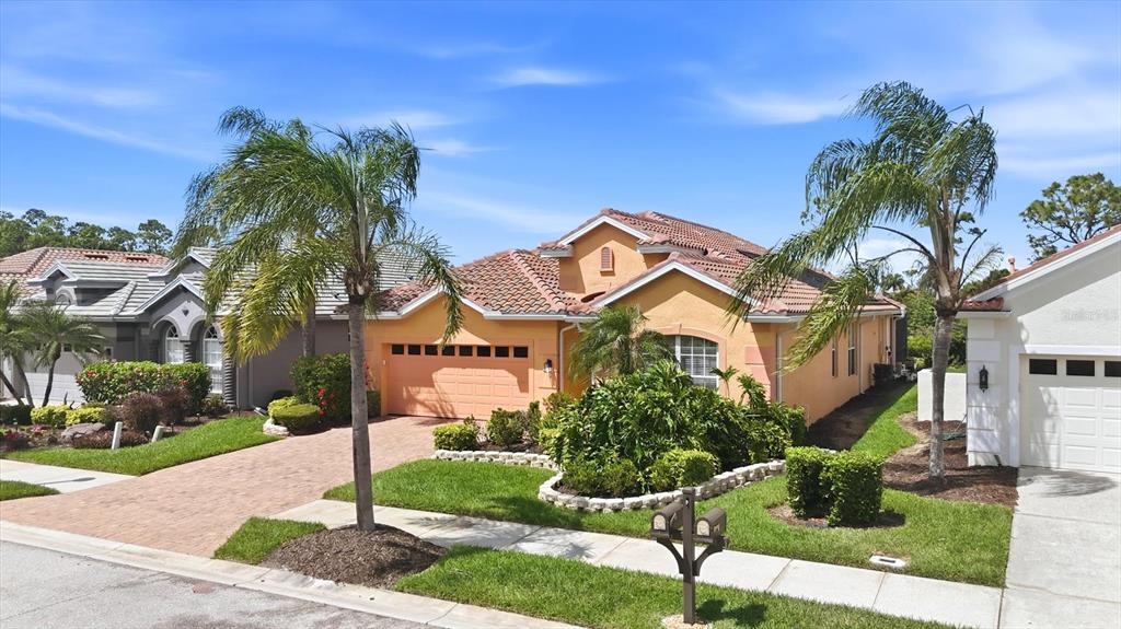 A single-story orange stucco house with a tiled roof and a brick paver driveway — 4811 BLUE HERON CIRCLE, NORTH PORT, FL