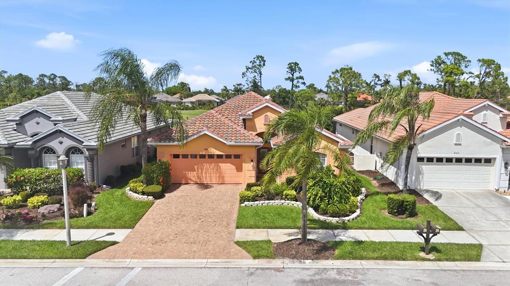 An exterior view of a single-story house with a tile roof and brick driveway — 4811 BLUE HERON CIRCLE, NORTH PORT, FL