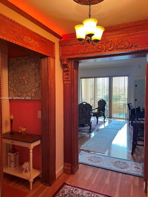A hallway with a wooden entryway leads to a dining area with a chandelier — 16102 Emerald Estates Dr # 235, Weston FL 33331, WESTON, FL