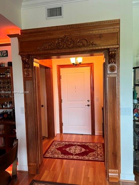 A wooden doorway with ornate trim leads to a white front door with a rug — 16102 Emerald Estates Dr # 235, Weston FL 33331, WESTON, FL