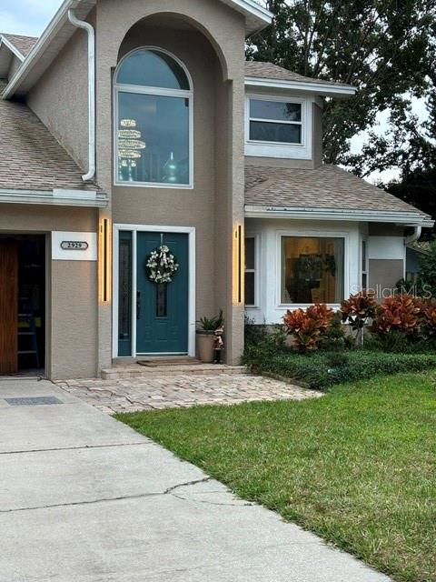 The exterior of a two-story house features a teal front door and a stone walkway — 2929 SOMERSWORTH COURT, ORLANDO, FL
