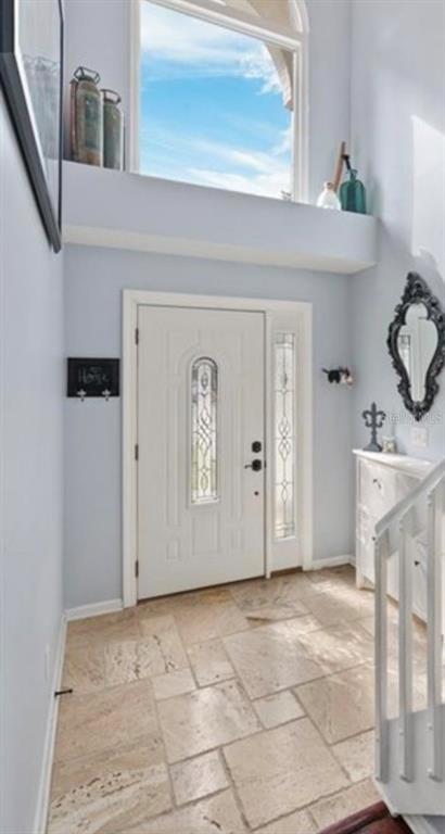 A bright entryway features a white front door, tile flooring, and a large arched window — 2929 SOMERSWORTH COURT, ORLANDO, FL