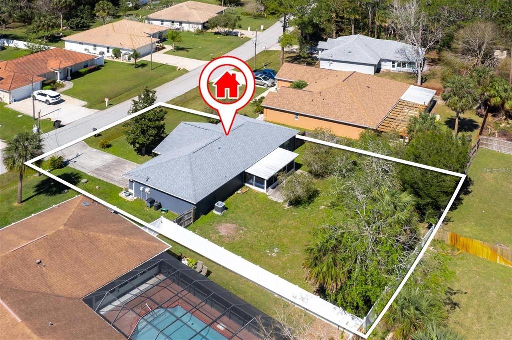 An aerial view shows a single-story house with a gray roof and a fenced backyard — 17 PINELARK LANE, PALM COAST, FL